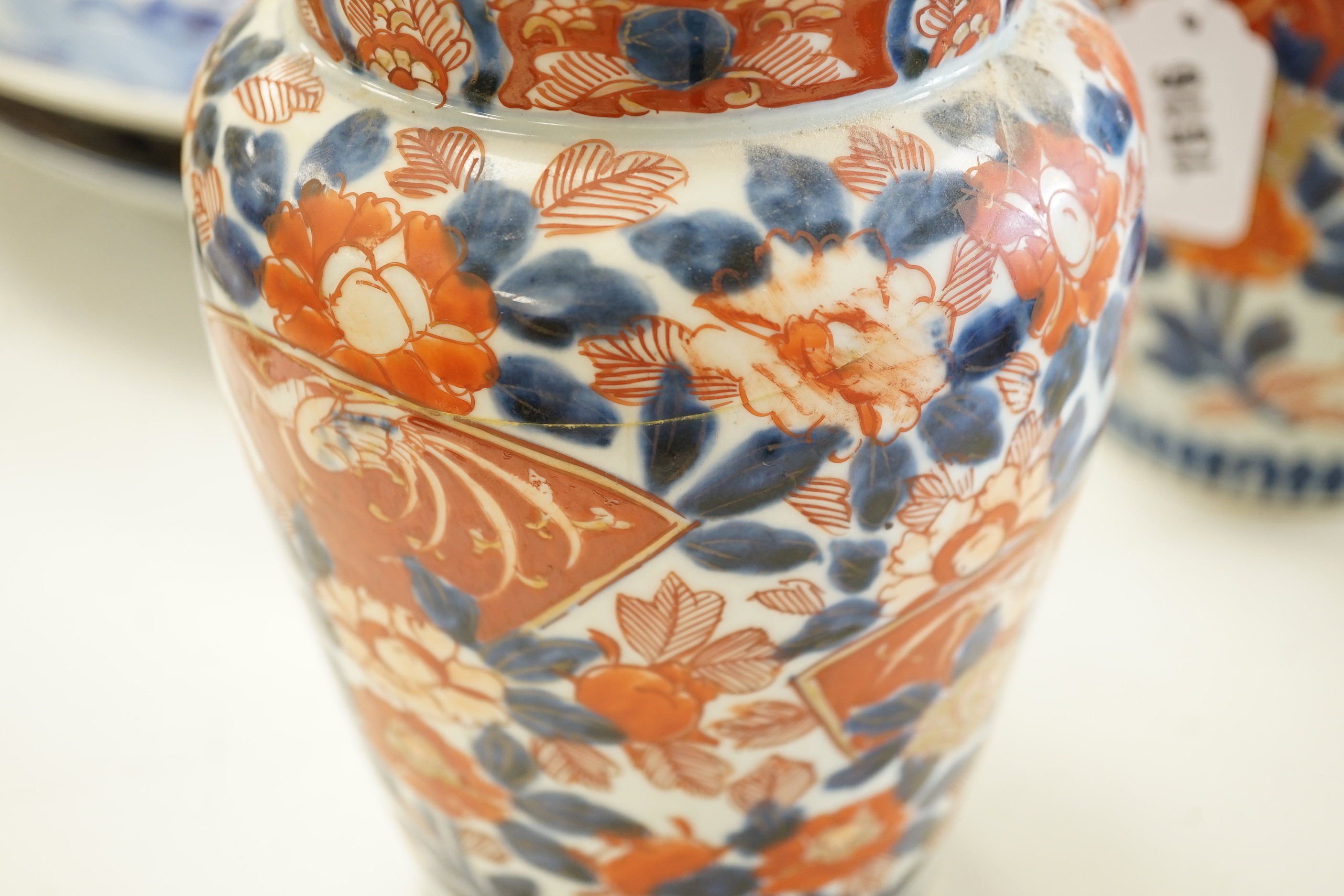 A pair of 19th century Japanese Imari vases, a similar charger, an earlier cracked and riveted charger and a blue and white charger, (5), largest charger 47cm diameter